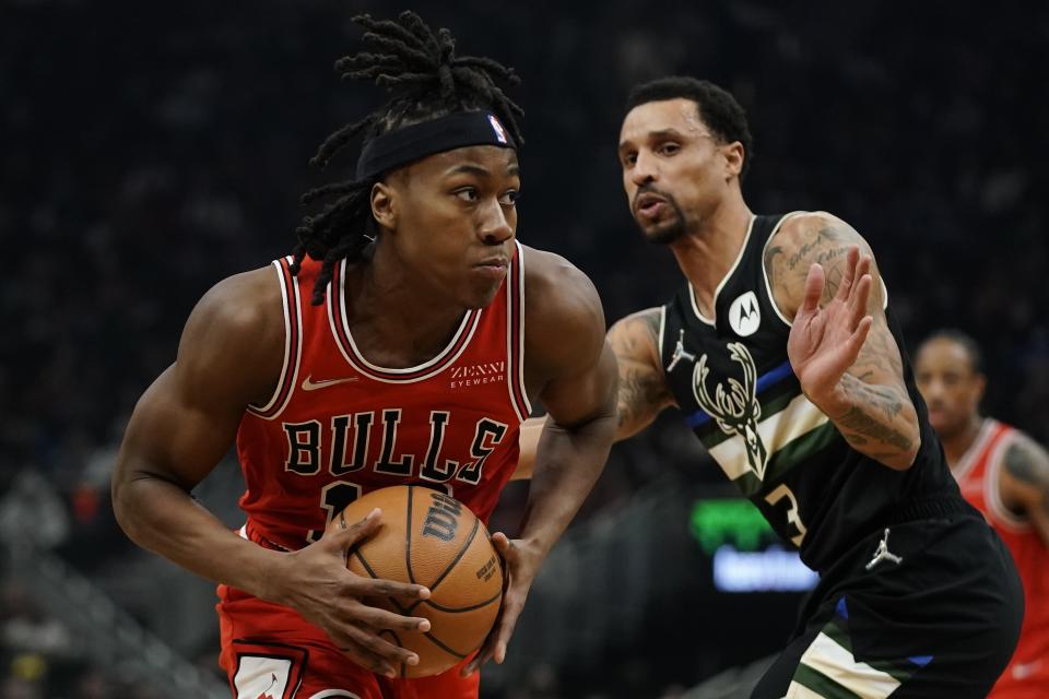 Chicago Bulls' Ayo Dosunmu drives past Milwaukee Bucks' George Hill during the first half of an NBA basketball game Friday, Jan. 21, 2022, in Milwaukee. (AP Photo/Morry Gash)