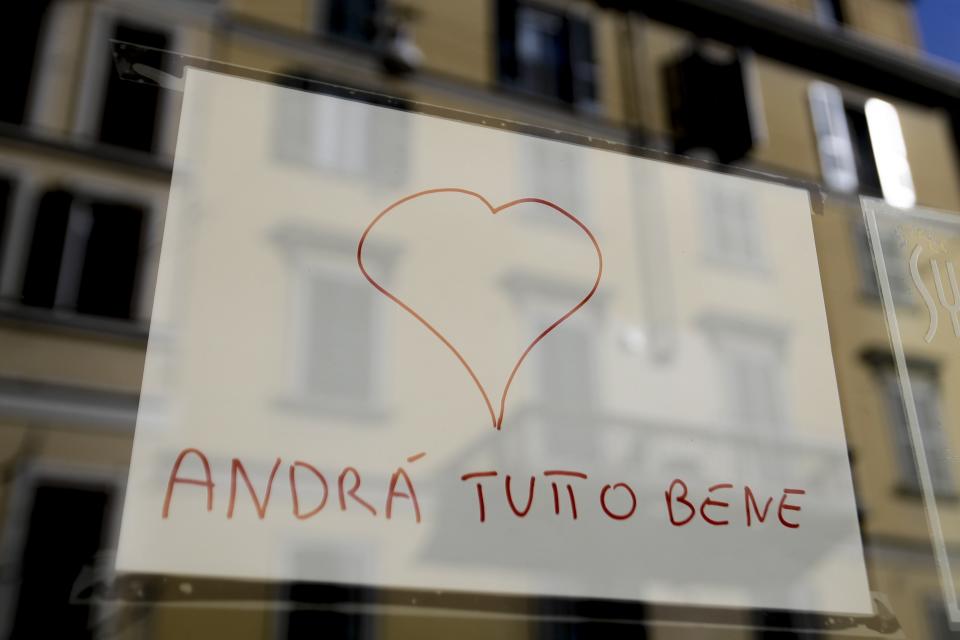 In this photo taken on Wednesday, March 11, 2020, a note reading in Italian "Everything will be alright" hangs on the window of a shop in Milan, Italy, Wednesday, March 11, 2020. The nationwide lockdown to slow coronavirus is still early days for much of Italy, but Italians are already are showing signs of solidarity. This week, children’s drawings of rainbows are appearing all over social media as well as on balconies and windows in major cities ready, ‘’Andra’ tutto bene,’’ Italian for ‘’Everything will be alright.’’ For most people, the new coronavirus causes only mild or moderate symptoms. For some, it can cause more severe illness, especially in older adults and people with existing health problems. (AP Photo/Luca Bruno)