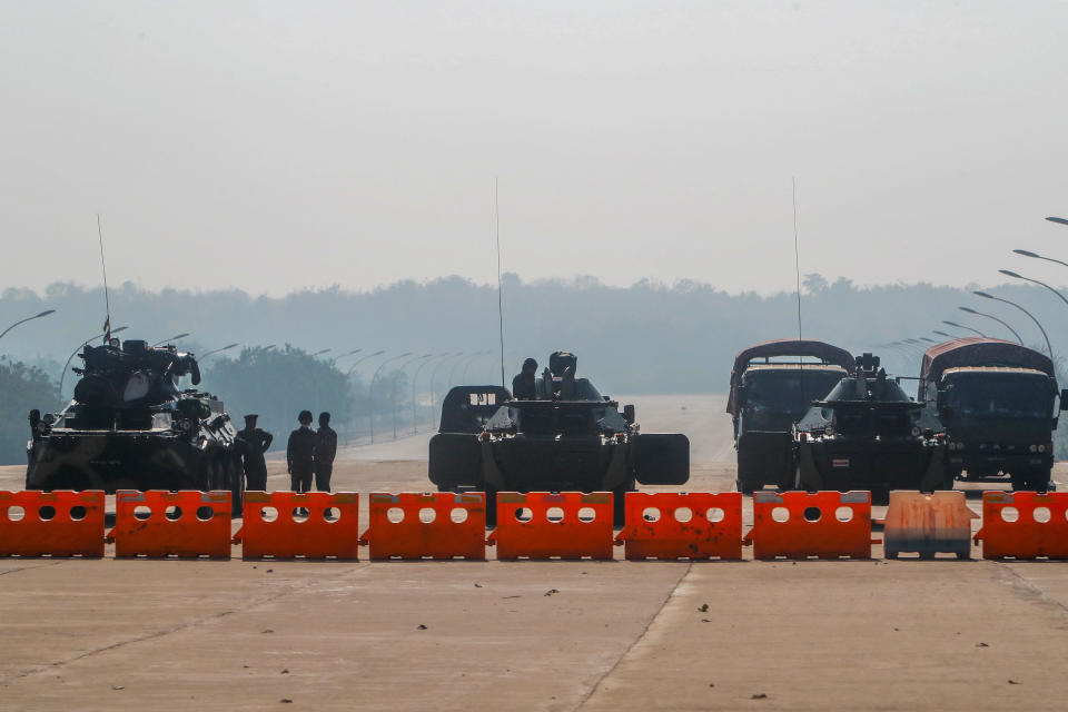 Myanmar's military stand guard at a checkpoint manned with an armored vehicles blocking a road leading to the parliament building, February 2, 2021, in Naypyitaw, Myanmar. / Credit: AP