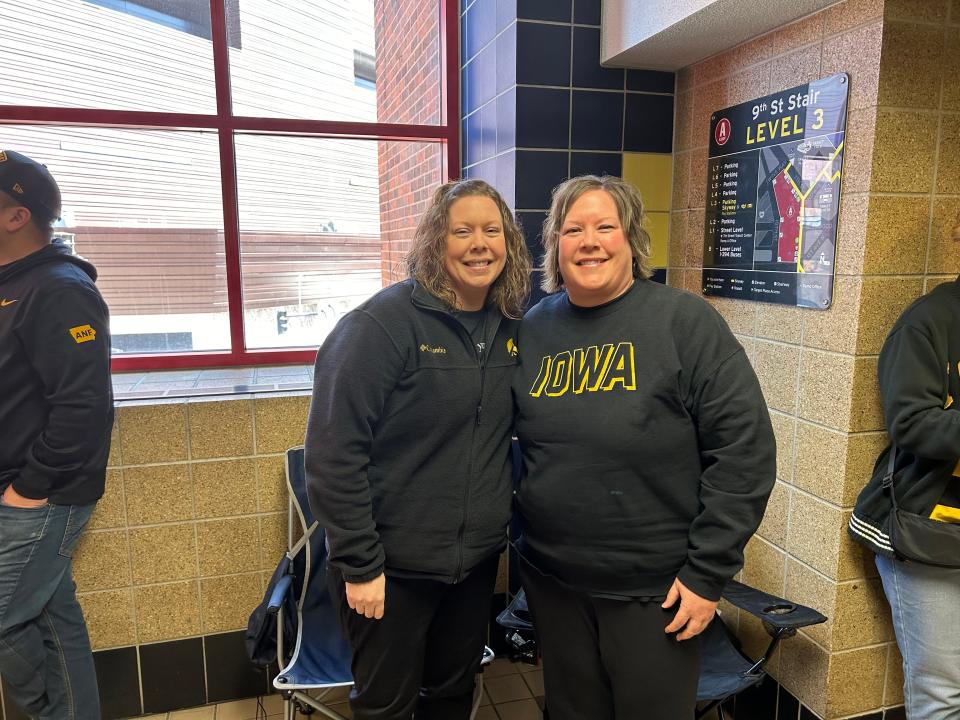 Iowa fans Heather Ritzema (left) and Renee Van Kooten pose for a photo while waiting to get into the Target Center in Minneapolis to see Caitlin Clark and Iowa women's basketball. Ritzema and Van Kooten brought chairs, books, and snacks for their 3-hour wait.