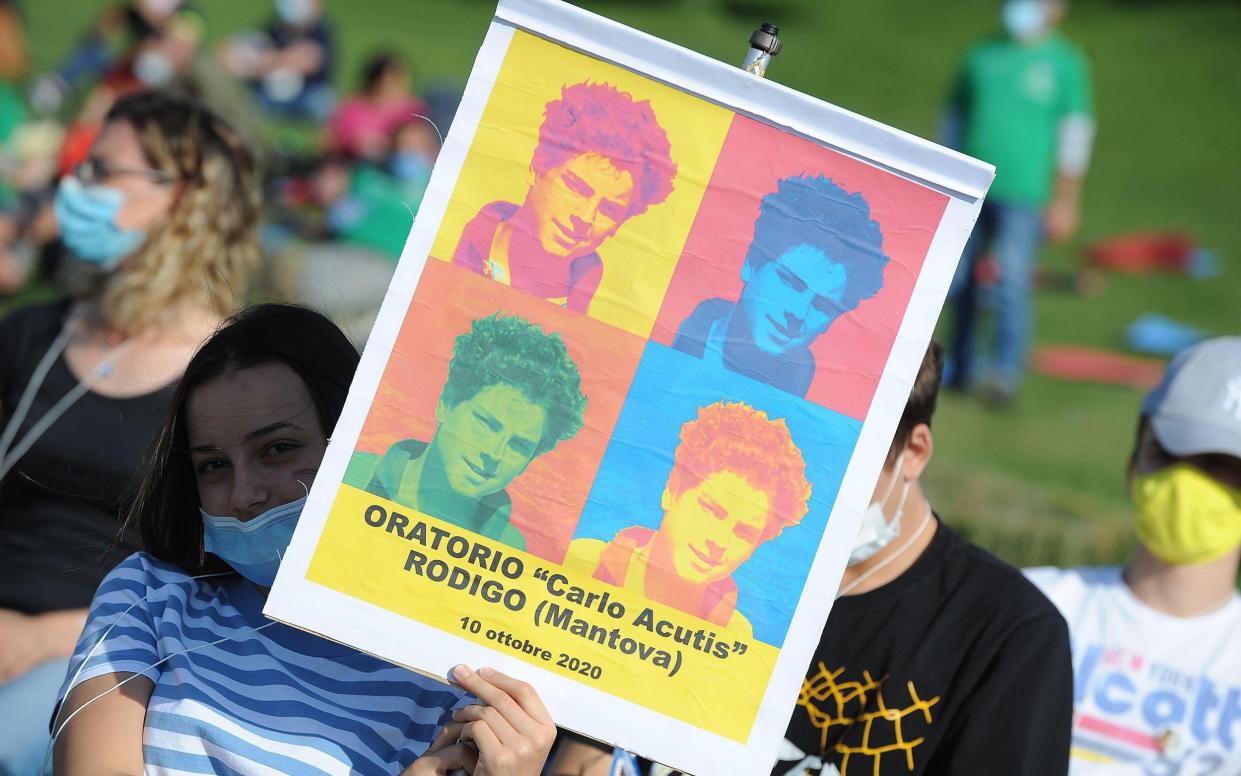 People holding sign of Carlo Acutis