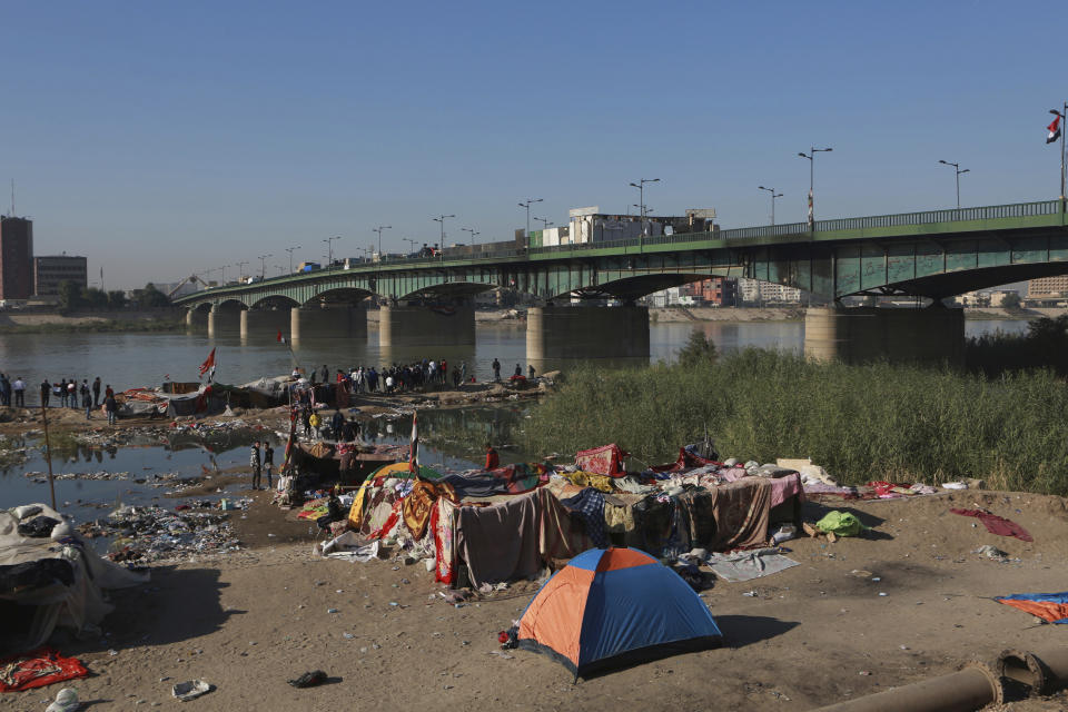 Anti-government protesters stage a sit-in while security forces close a bridge leading to the Green Zone government areas, during ongoing protests in Baghdad, Iraq, Thursday, Nov. 21, 2019. Iraqi officials say three anti-government protesters have been killed in clashes with security forces overnight in Baghdad. (AP Photo/Khalid Mohammed)