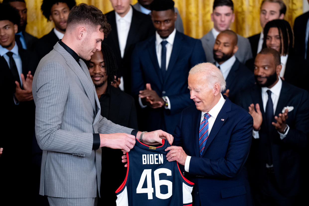 WASHINGTON, DC - SEPTEMBER 10: Center Donovan Clingan (L) presents U.S. President Joe Biden with a team jersey during a celebration of the 2023-2024 University of Connecticut Huskies Men's Basketball NCAA championship team in the East Room of the White House on September 10, 2024 in Washington, DC. The Huskies beat the Purdue Boilermakers 75-60 for their sixth NCAA Championship and their second championship in a row. (Photo by Andrew Harnik/Getty Images)