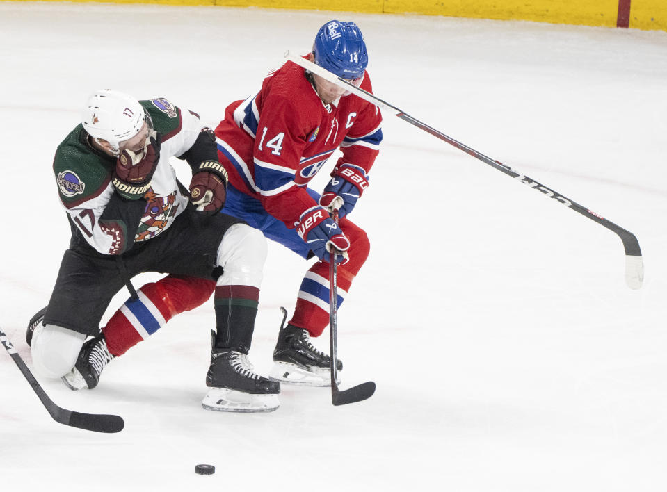 Arizona Coyotes' Nick Bjugstad (17) loses his stick after a high-stick as he works against Montreal Canadiens' Nick Suzuki (14) during the second period of an NHL hockey game Tuesday, Feb. 27, 2024, in Montreal. (Christinne Muschi/The Canadian Press via AP)