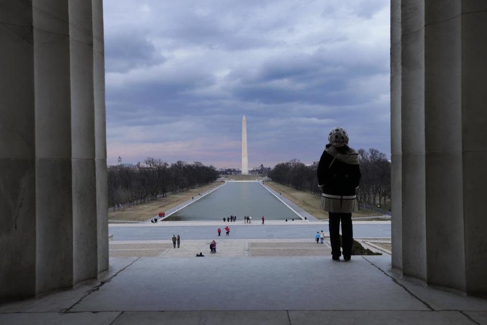 This Feb. 28, 2013 photo shows a visitor viewing the National Mall from the Lincoln Memorial looking towards the Washington Monument and the U.S. Capitol in Washington. There are probably more free things to do in the U.S. capital than nearly any other major city in the world. The most popular museums and the zoo are free, thanks to government funding, as well as the picturesque memorials and monuments. With so many free options, the biggest challenge might be narrowing down what to see. (AP Photo/Alex Brandon)