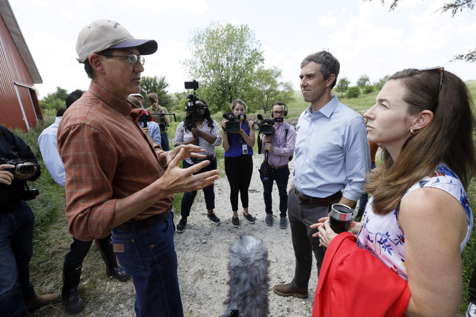 Democratic presidential candidate Beto O'Rourke, center, and his wife Amy, right, talk with Matt Russell, left, while touring his Coyote Run Farm, Friday, June 7, 2019, in Lacona, Iowa. (AP Photo/Charlie Neibergall)
