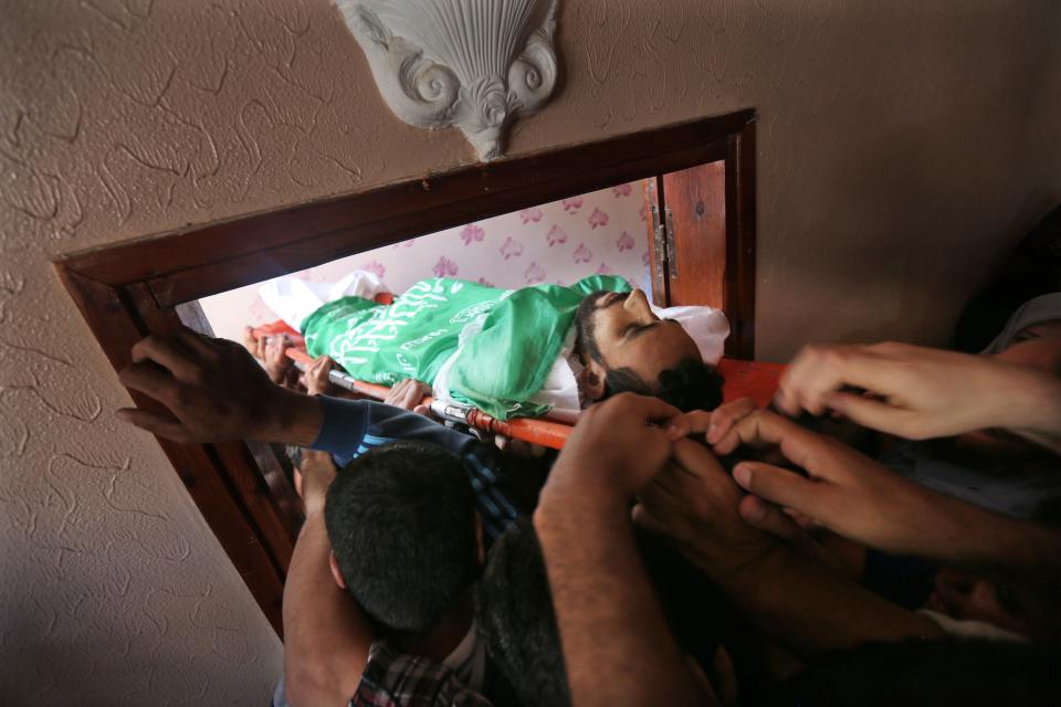 <p>Mourners carry the body of Mohammed Dwedar, a 27 year-old Palestinian killed during clashes along the Gaza border the previous day, during his funeral in Nusseirat refugee camp in the Gaza Strip on May 15, 2018. (Photo: Mohammed Abed/AFP/Getty Images) </p>