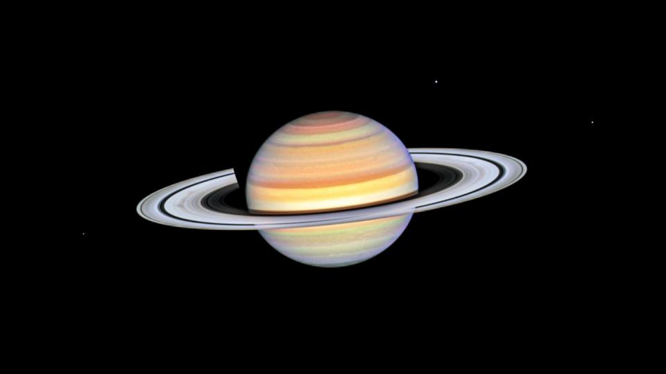 Die Speichen des Saturn sind als dunkle Druckstellen auf der linken Seite der Planetenringe zu sehen. - Copyright: NASA, ESA, STScI, Amy Simon (NASA-GSFC)