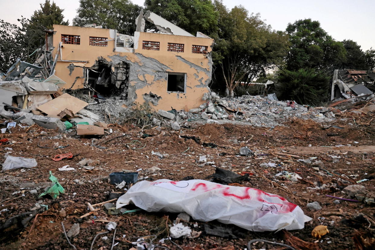 Un corps au milieu des ruines dans le kibboutz de Be'eri près de la bande de Gaza, après l'attaque du Hamas contre Israël.    - Credit:MENAHEM KAHANA / AFP