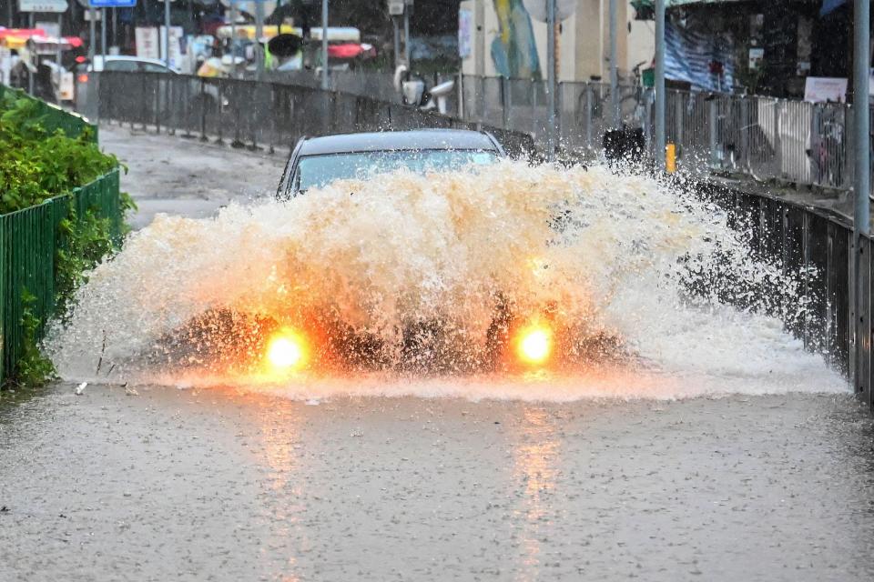 A motorist drives through floodwaters on Lantau Island in Hong Kong on September 8, 2023.