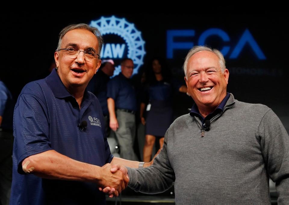 Sergio Marchionne, left, and Dennis Williams, who was then UAW president but later convicted in the corruption scandal, shake hands during a ceremony to mark the opening of contract negotiations between the UAW and Fiat Chrysler Automobiles in Detroit in 2015. General Motors claims that Marchionne, the late, former CEO of FCA, corrupted the bargaining process to hurt GM and has taken its case against FCA US, the U.S. operating arm of Stellantis, to the U.S. Supreme Court.