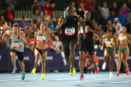 Jamaica's Olympic champion Usain Bolt runs after receiving the baton from team mate and compatriot Asafa Powell during the final night of the Nitro Athletics series at the Lakeside Stadium in Melbourne, Australia, February 11, 2017. REUTERS/Hamish Blair