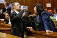 Oscar Pistorius drinks water in court in Pretoria, South Africa, Friday, March 14, 2014, prior to his tenth day in court. Pistorius is charged with the shooting death of his girlfriend Reeva Steenkamp, on Valentines Day in 2013. (AP Photo/Kim Ludbrook, Pool)