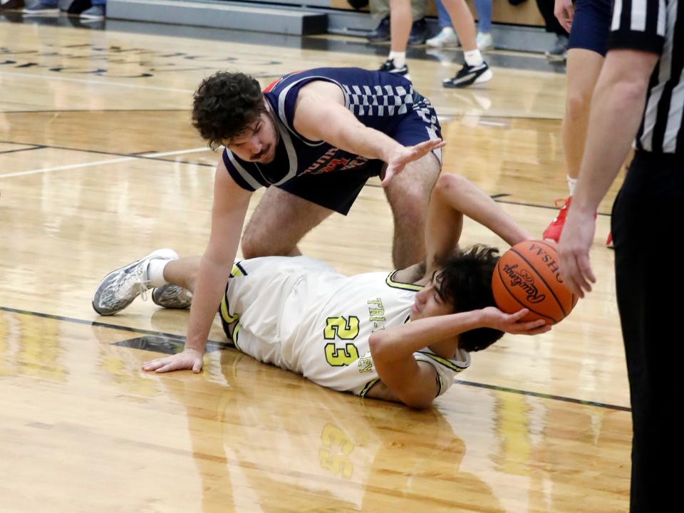 Ryan Lamonica looks for an open teammate while Cutter Myers tries to steal the ball during Tri-Valley's 72-29 win against visiting Morgan on Friday night in Dresden.