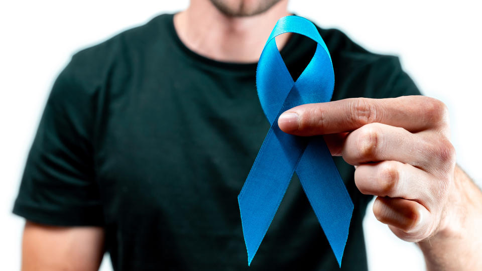 November. Hipster men in dark shirt with blue ribbon in hands isolated on white background. Awareness prostate cancer of men health. Supporting people living and illness