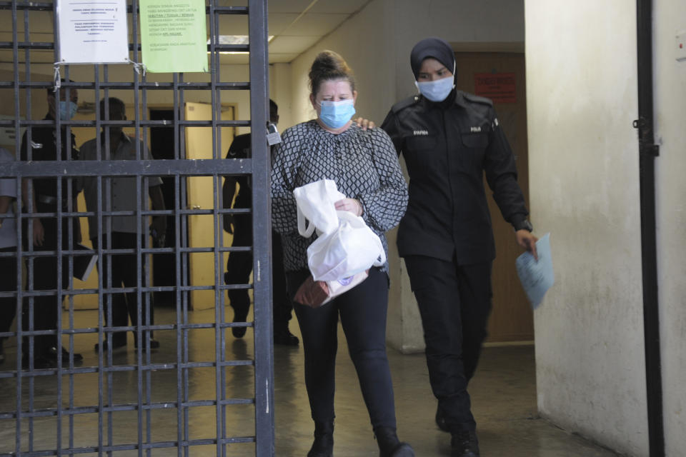 British woman Samantha Jones, left, leaves Alor Setar's courthouse, Kedah state, Malaysia, Monday, Aug. 3, 2020. Jones, accused of stabbing her husband to death at their Malaysian resort home avoided the gallows and was sentenced to 42 months in jail on Monday after she pleaded guilty to a lesser charge. (AP Photo/Eric Tan)