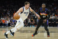 Dallas Mavericks guard Luka Doncic (77) drives as Phoenix Suns forward Jae Crowder (99) defends during the second half of Game 7 of an NBA basketball Western Conference playoff semifinal, Sunday, May 15, 2022, in Phoenix. The Mavericks defeated the Suns 123-90. (AP Photo/Matt York)