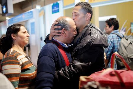 Christian Syrian refugee Issa Aleid, embraces his son Ghassan (R), after the father arrived with fifteen family members from Beirut, at the Charles-de-Gaulle Airport in Roissy, France, October 2, 2015. REUTERS/Stephane Mahe