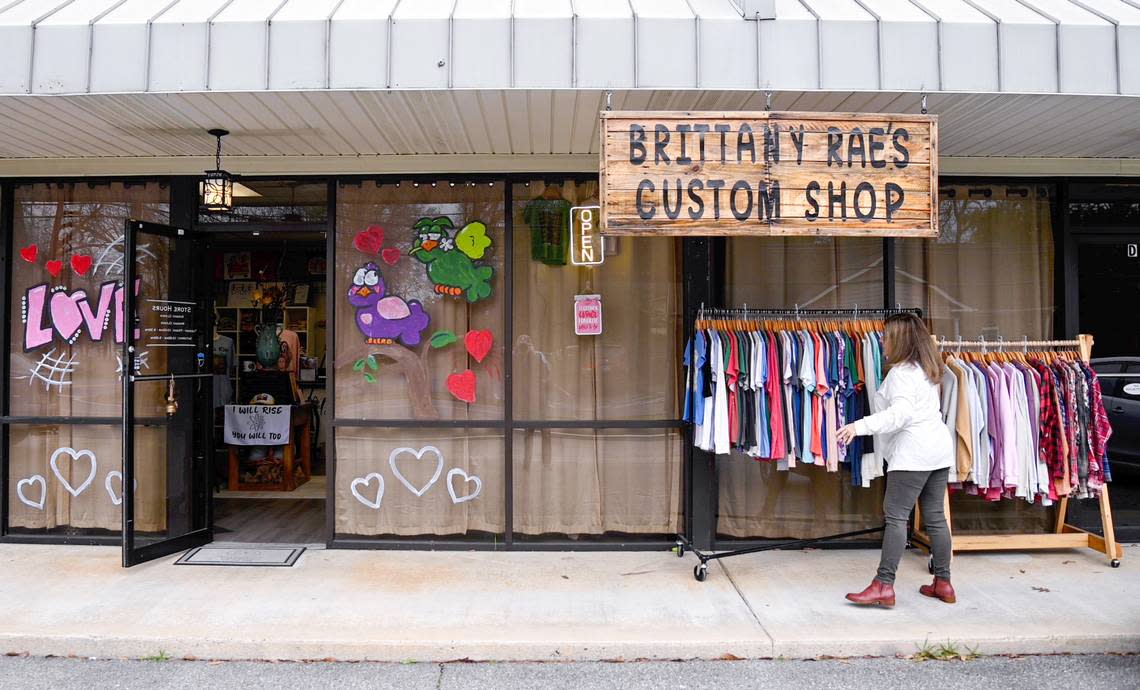 Athena Richardson, owner of Brittany Rae’s Custom Shop puts out a rack of merchandise at her Byron boutique. Richardson expanded the storefront and a grand opening was held last week.