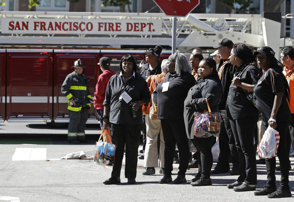 Ballpark employees wait outside AT&T Park after a concession stand fire broke out before a baseball game between the Houston Astros and the San Francisco Giants, Monday, Aug. 6, 2018, in San Francisco. The fire was put out by the time firemen arrived and there was no expected delay of the game. (AP Photo/Eric Risberg)