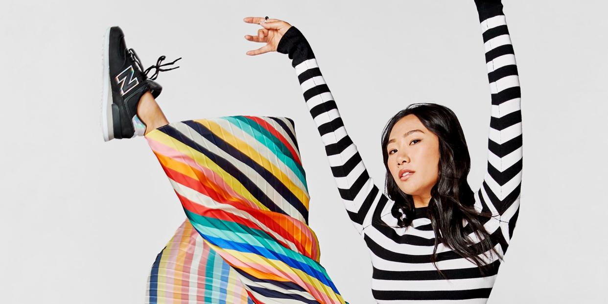 olivia liang wearing a striped outfit, kicking her leg in the air