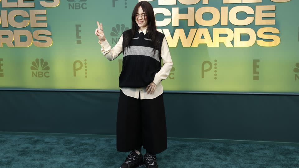 With her hair back to all black, Billie Eilish chose a sweater vest, shirt and tie combo teamed with baggy trousers and chunky shoes. The singer won the "TV Performance of the Year" award for her appearance in "Swarm." - Michael Tran/AFP/Getty Images