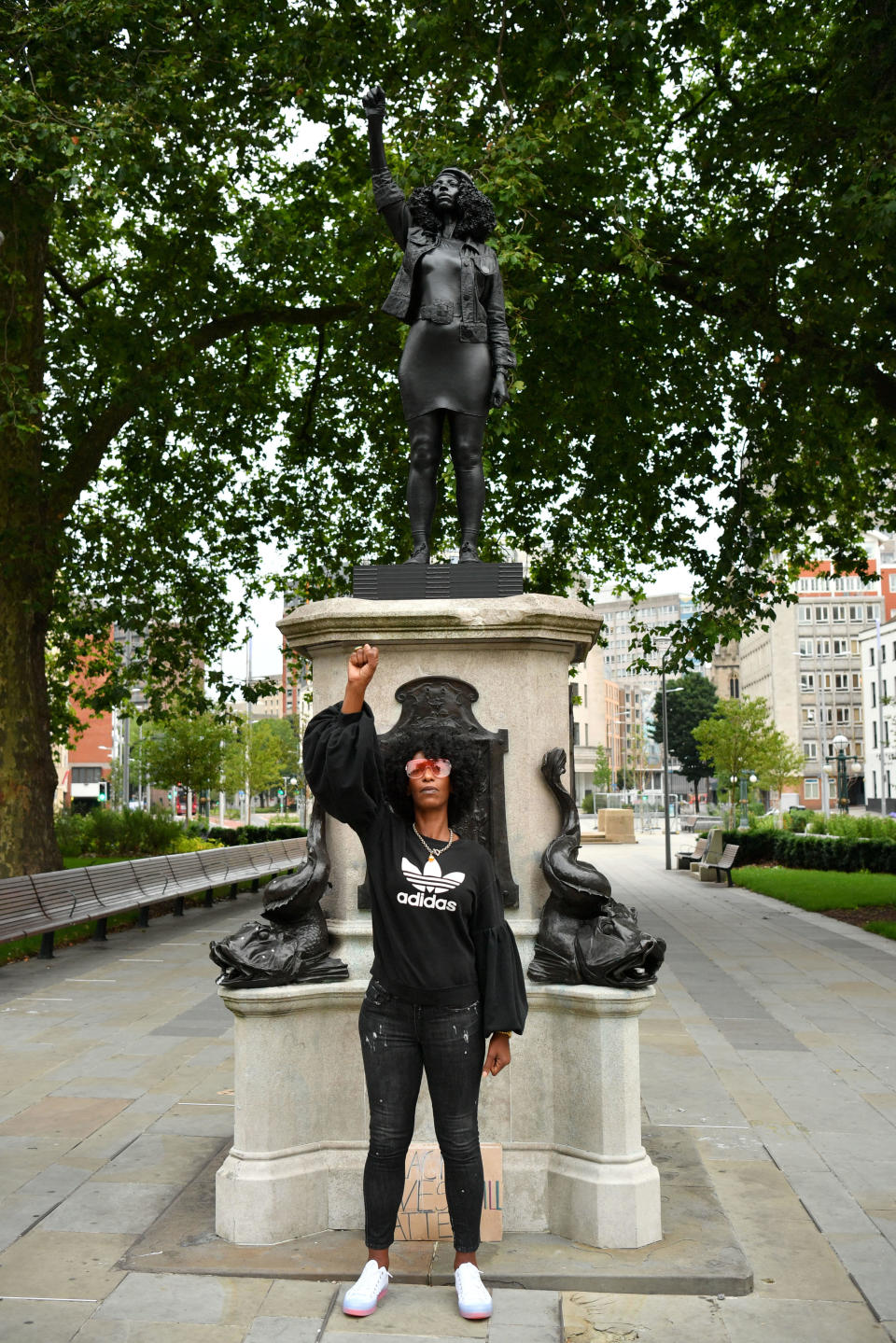 Black Lives Matter protestor Jen Reid poses for a photograph in front of a sculpture of herself, by local artist Marc Quinn, on the plinth where the Edward Colston statue used to stand on July 15, 2020 in Bristol, England. / Credit: Getty Images
