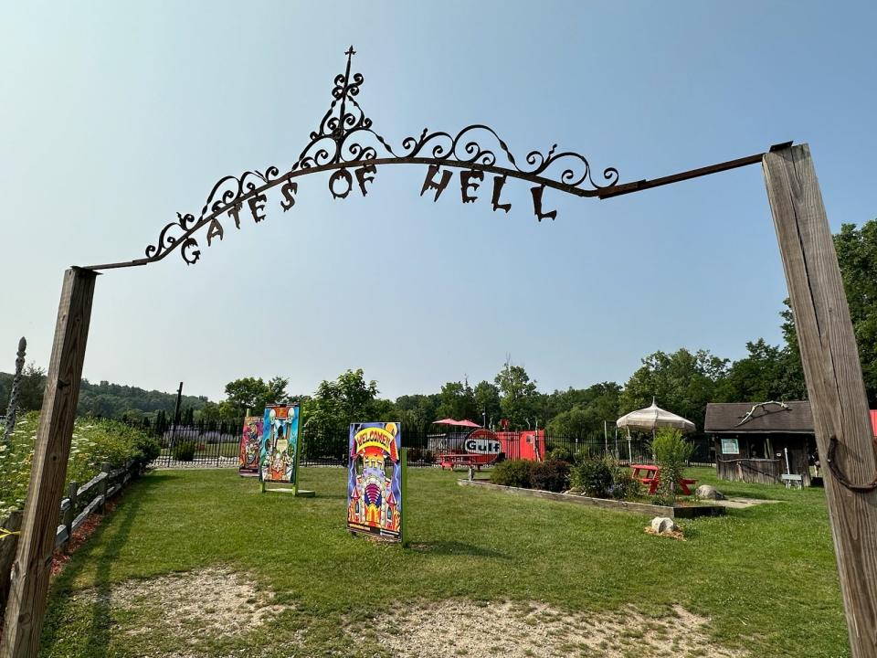 Metal gates of hell arch over a selection of cut-out photo motifs in Hell, Michigan