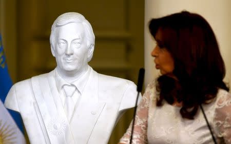 Argentina's President Cristina Fernandez de Kirchner speaks next to a figure of her husband late Argentine President Nestor Kirchner during a ceremony on her last day in office at the Casa Rosada Presidential Palace in Buenos Aires, Argentina, December 9, 2015. REUTERS/Marcos Brindicci