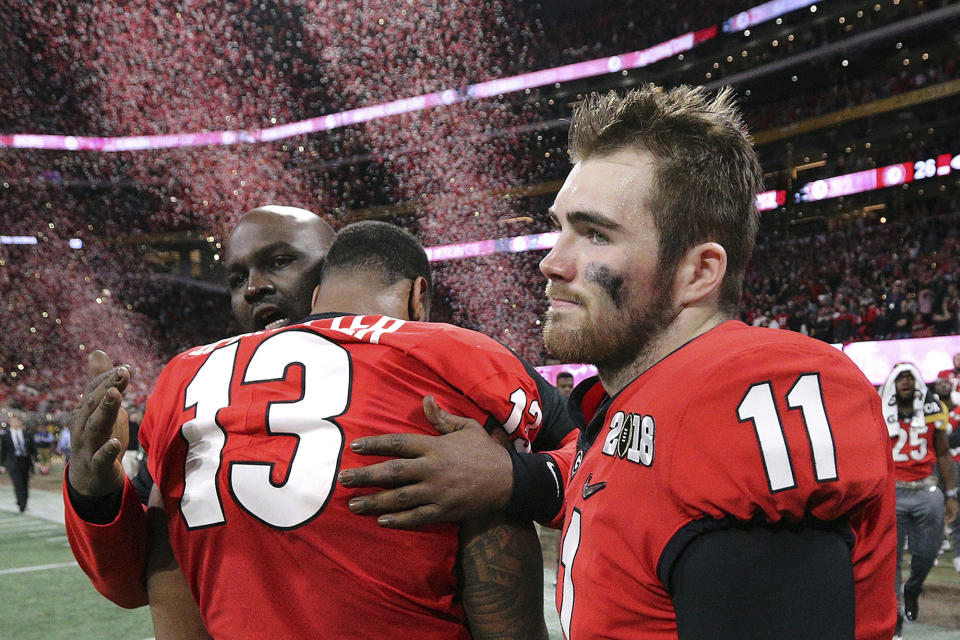 FILE- In this Jan. 8, 2018, file photo, Georgia's Jake Fromm and Jonathan Ledbetter reacts after their overtime lose to Alabama in College Football Playoff National Championship game in Atlanta. As the World Series comes to Atlanta for the first time since 1999, there is hope that the city — once immortalized by Sports Illustrated as “Loserville” — and the entire state of Georgia, for that matter, could be taking a turn toward some long-overdue parades and celebrations. (Curtis Compton/Atlanta Journal-Constitution via AP, File)