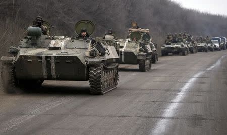 Members of the Ukrainian armed forces ride armoured personnel carriers as they pull back from Debaltseve region, near Artemivsk February 26, 2015. REUTERS/Gleb Garanich