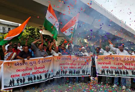 People wave national flags to celebrate after India said it had conducted targeted strikes across the de facto frontier, in Ahmedabad, India, September 29, 2016. REUTERS/Amit Dave