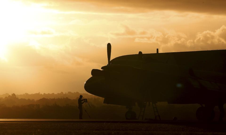 A ground crewman stands in front of a South Korean P3 Orion after it returned from the search for missing Malaysia Airlines Flight MH370 in Perth, Australia, Sunday, March 30, 2014. Australia's Prime Minister Tony Abbott said Sunday he was hopeful clues will emerge soon to help find Flight 370 even though searchers again failed to find jet debris, as relatives of Chinese passengers on the plane protested in Malaysia to demand the government apologize over its handling of the search. (AP Photo/Rob Griffith)