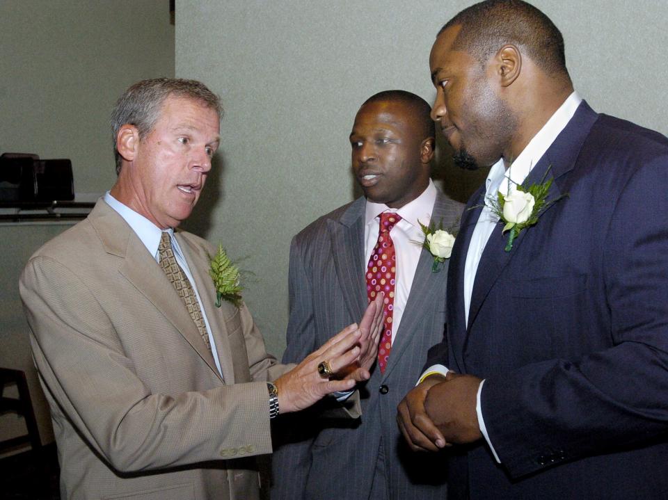 Former McKinley football coach Thom McDaniels  (left) talks with former Bulldog stars Mike Doss (center) and Kenny Peterson prior to the trio's 2010 induction into the Stark County High School Hall of Fame. The trio helped McKinley win the 1997 Division I state title and the USA Today national championship.