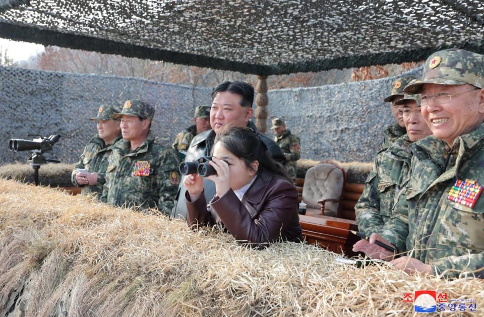 Kim Ju-ae looks through binoculars at an event