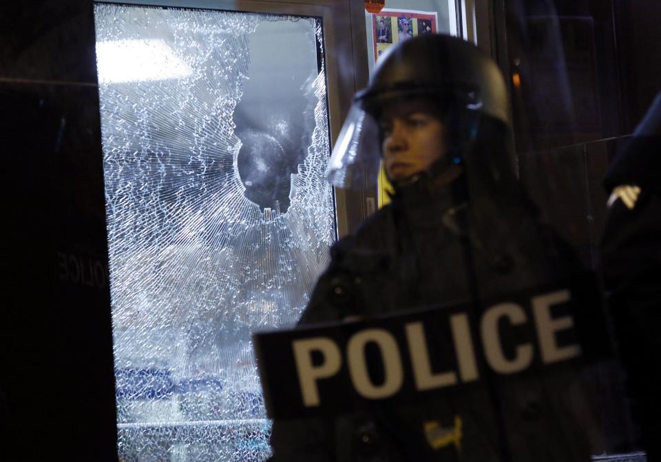 A police officer stands guard in front of a damaged storefront during a protest after a vigil in St. Louis, Missouri, October 9, 2014. Police clashed with protesters in St. Louis on Thursday for a second consecutive night, a day after a 32-year-old white St. Louis police officer fatally shot a black teenager, 18-year-old Vonderrit Myers Jr., ahead of a weekend of planned marches and rallies in the area over the August killing of unarmed black teenager Michael Brown. (REUTERS/Jim Young)