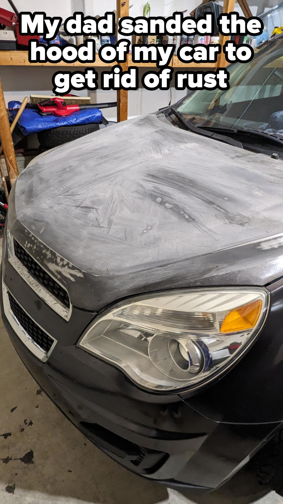 Front view of a car with a faded-looking hood, parked in a garage, with caption, "My dad sanded the hood of my car to get rid of rust"