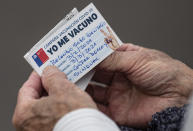 FILE - In this Wednesday, Feb. 3, 2021, file photo, an elderly man looks at his vaccination card after getting a shot of the CoronaVac vaccine for COVID-19 developed by China's biopharmaceutical company Sinovac Biotech, at a clinic in Santiago, Chile. It wasn’t until Sinovac swooped in with 4 million doses in late January that Chile began inoculating its population of 19 million with impressive speed. (AP Photo/Esteban Felix, File)