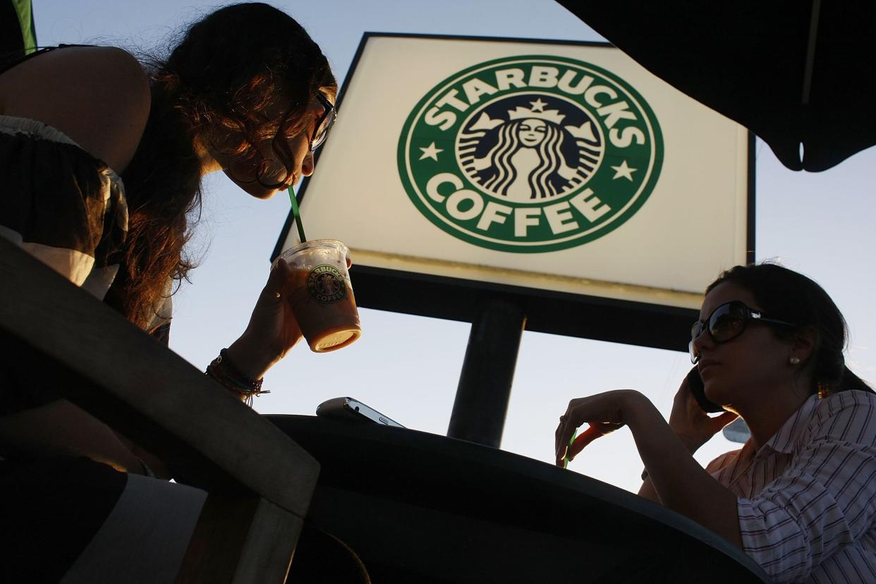 Customers relax and drink their beverages at a Starbucks Coffee shop on January 28, 2009 in Miami, Florida.