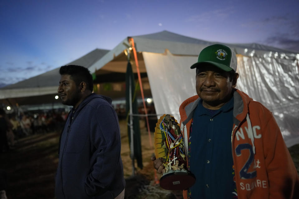 A man carries a figure of the Virgin of Guadalupe, as he attends a festival celebrating one of several apparitions of the Virgin Mary witnessed by an indigenous Mexican man named Juan Diego in 1531, at St. Ann Mission in Naranja, Fla., before dawn on Sunday, Dec. 10, 2023. For this mission church where Miami's urban sprawl fades into farmland and the Everglades swampy wilderness, it's the most important event of the year, both culturally and to fundraise to continue to minister to the migrant farmworkers it was founded to serve in 1961. (AP Photo/Rebecca Blackwell)