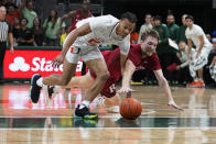 Miami's guard Isaiah Wong (2) and Rutgers' guard Cam Spencer (10) go after the ball during the first half of an NCAA college basketball game, Wednesday, Nov. 30, 2022, in Coral Gables, Fla. (AP Photo/Marta Lavandier)