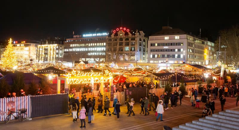 Visitors queue to get their COVID-19 health certificates checked at a Christmas market in Zurich