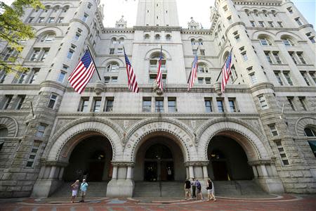 U.S. flags fly on the Old Post Office in Washington September 10, 2013. REUTERS/Kevin Lamarque