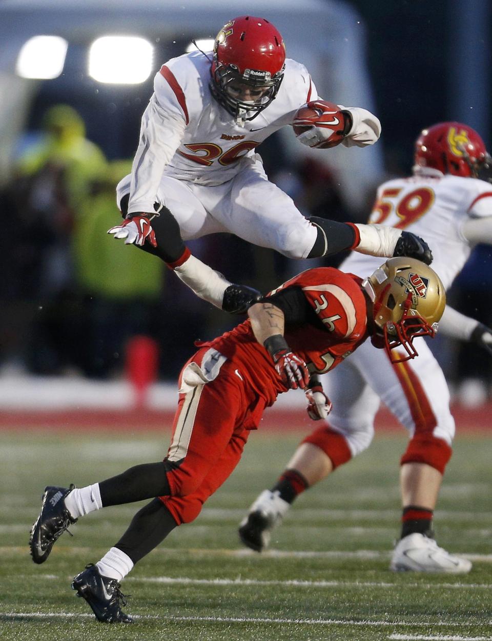 Calgary Dinos Mercer Timmis, top, jumps over Laval Rouge et Or Vincent Plante during the second half of the Vanier Cup University Championship football game in Quebec City, Quebec, November 23, 2013. REUTERS/Mathieu Belanger (CANADA - Tags: SPORT FOOTBALL)