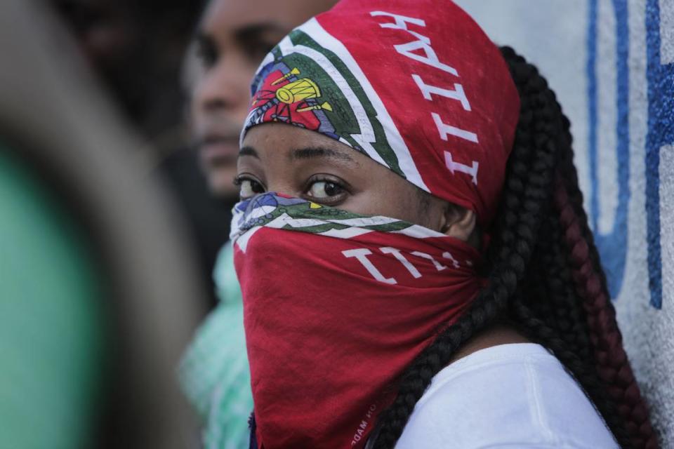 A young woman conceals her identity during a protest in front of Haiti National Police headquarters in Port-au-Prince on Nov. 17, 2019. Officers of the Haitian National Police took to the streets demanding better working conditions and a union to protect their rights.