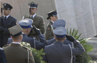 Polish Army and police officers lay wreaths at the memorial dedicated to the victims of the 2010 presidential plane crash, during a ceremony at the Powazki cemetery in Warsaw, Poland, Monday, April 10, 2017. Wreath-laying ceremonies and prayers opened Poland's state observances of the seventh anniversary of a plane crash in Russia that killed President Lecha Kaczynski, the first lady and 94 others. (AP Photo/Alik Keplicz)