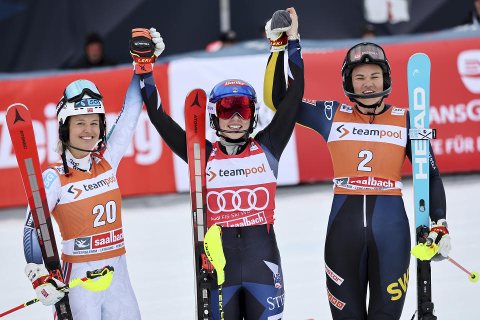 United States' Mikaela Shiffrin, center, winner of an alpine ski, women's World Cup slalom race, celebrates with second-placed Norway's Mina Fuerst Holtmann, left, and third-placed Sweden's Anna Swenn Larsson, in Saalbach, Austria, Saturday, March 16, 2024. (AP Photo/Marco Trovati)