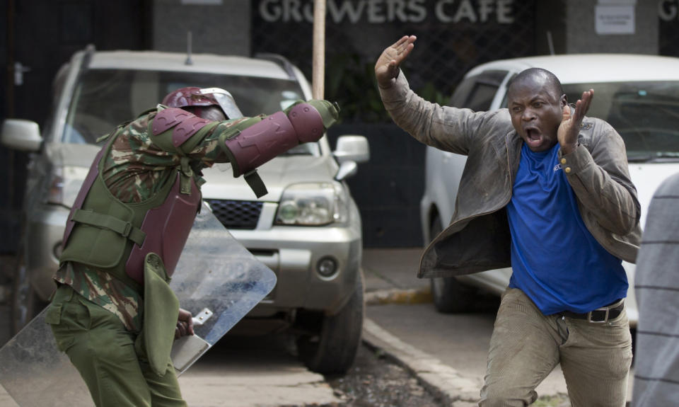 An opposition supporter yells as he is beaten with a wooden club by riot police while trying to flee during a protest in downtown Nairobi, Kenya, May 16, 2016. Kenyan police have tear-gassed and beaten opposition supporters during a protest demanding the disbandment of the electoral authority over alleged bias and corruption. (AP Photo/Ben Curtis)