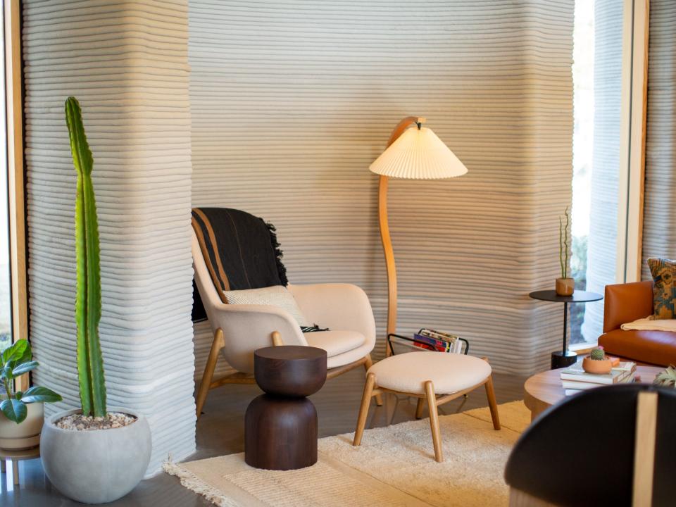 A lounge chair next to a light in the living room.