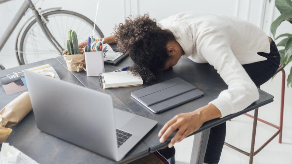 Una mujer tendida sobre su laptop